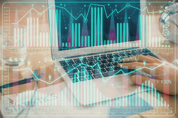 Multi exposure of market chart with man working on computer on background. Concept of financial...