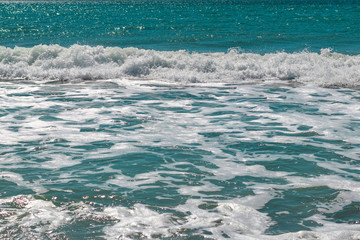 foamy sea waves on a sandy beach with texture effect