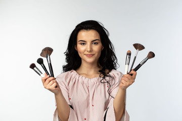 Make-up artist holding brushes