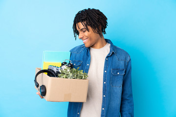 Young African American man making a move while picking up a box full of things with happy expression