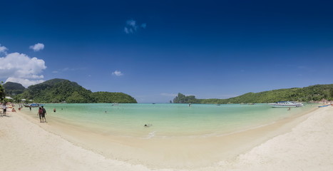 view seaside panorama on white sand beach with blue-green sea, mountains and blue sky background, Loh Dalum Bay, Phi Phi Don island, Krabi, southern of Thailand.