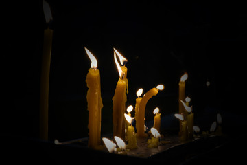 Light from yellow candle burning in dark.