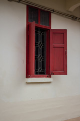 White building with red shutters and window frames