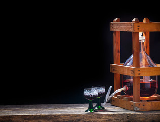 Making wine yourself, wine balloon with red wine glasses in the wine cellar