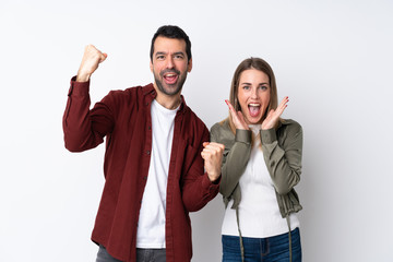 Couple in Valentine Day over isolated background celebrating a victory