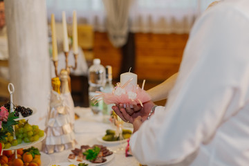 Beautiful newlyweds light a candle at a wedding celebration.