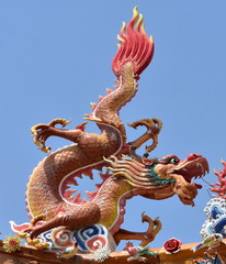 Fototapeta na wymiar Colorful dragon statue on the roof of a Chinese temple in front of a blue sky