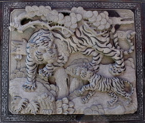 Stone carved decoration of tigers on the wall of a Chinese temple