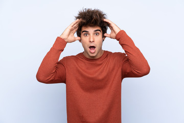 Fototapeta premium Młody człowiek kaukaski na białym tle niebieski z wyrazem zaskoczenia