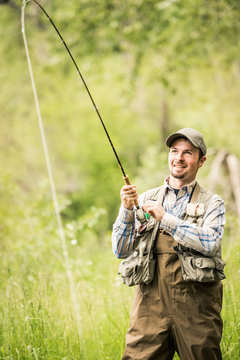 Fly fisherman trying to reel in a fish. Red Lodge, Montana, USA
