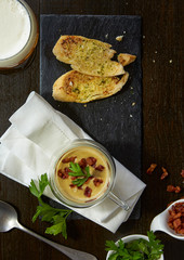 Bacon cream soup serve with garlic bread combine with spoon.