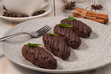 handmade chocolate bars on a light plate with a Cup and cinnamon sticks