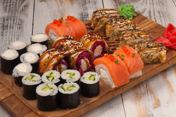 assorted rolls on a wooden Board. Rolls with eel, salmon, cream cheese, shrimp, cucumber