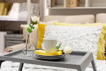 Fototapeta na wymiar Grey tray with coffee and flower, interior decor on the bed. Romantic breakfast in bed concept.