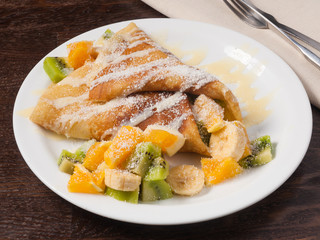 pancake with fruit orange banana kiwi and condensed milk