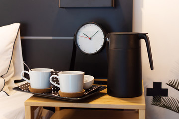 Morning coffee in modern interior decor near the bed.