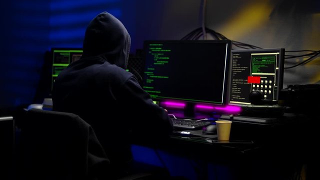 Tracking of thoughtful young male hacker in dark room