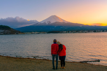 Fototapeta na wymiar Men and women look at Mount Fuji at sunset on holiday.