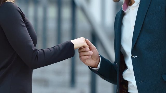 Close up unrecognized couple standing at street. Man kissing hand outdoors