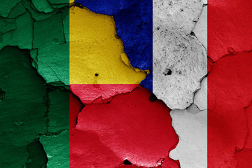 flags of Benin and France painted on cracked wall