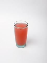  Red juice in a glass on a white background