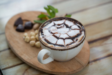 cup of coffee and nuts on wood table