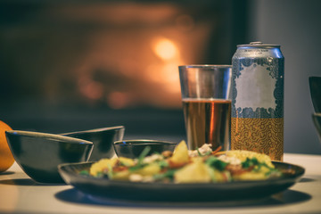 A healthy salad dinner with drinks over fireplace background. 