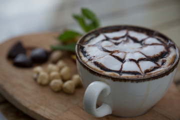 cup of coffee and nuts on wood table