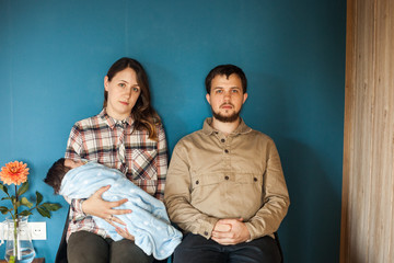 Lovely family of young parents and baby together at home