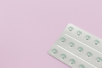 Pills in blister packs on a pink background