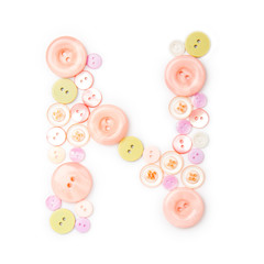 Letter N from pink and green buttons isolated on white background. Sewing kit. Colorful buttons, stylish alphabet for handmaking hobby. Handmade sew abc. Text from buttons