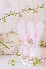 Happy easter. Decor and table setting of the Easter table is a vase with pink tulips and dishes of pink and green color.