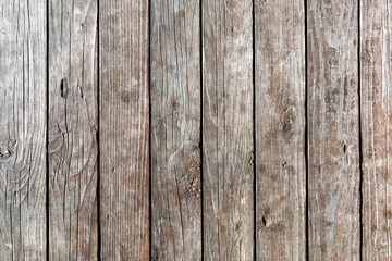 Fototapeta premium Background of old, weathered, dried-up, vertical wooden planks with deep cracks and knots. intricate pattern. Texture of wood. Free text space