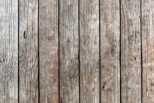 Background of old, weathered, dried-up, vertical wooden planks with deep cracks and knots. intricate pattern. Texture of wood. Free text space