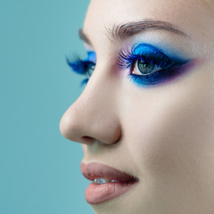 Fototapeta premium Glamorous bright eye makeup using the trend color classic blue, women's eyes close-up.