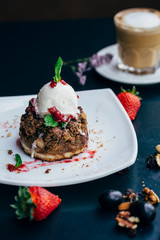 brownie and ice cream on a white plate with coffee and fruits