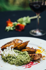 chicken with risotto on a white plate with wine a roses
