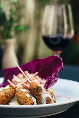 chicken with risotto on a white plate with wine a roses