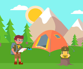 Boy scout holding paper map on campsite landscape