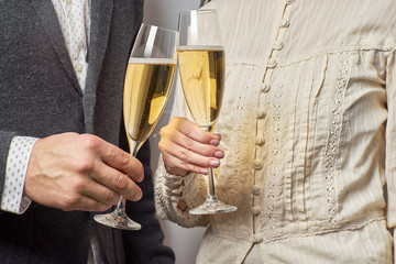 Male and female hands hold glasses of champagne