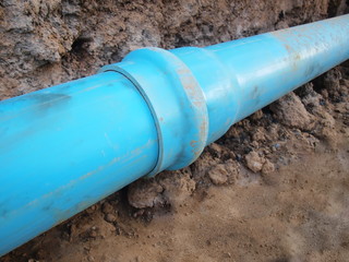 Blue pvc pipe joint Menstrual plastic plumbing pipes with wear joints On the ground background;...