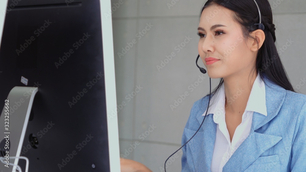 Poster customer support agent or call center with headset works on desktop computer while supporting the cu