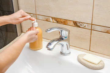 A Washing hands with soap under the faucet with water