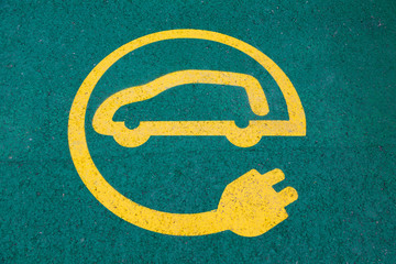 Se&ntilde;al de cargar para automovil el&eacute;ctrico en un parking