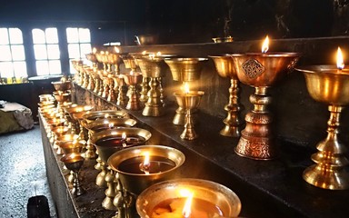 Golden Buddhist oil candles burn with apricot oil in temple in Ladakh