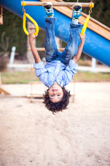 A kid boy climbing at the playground outdoor. Childhood and activity concept