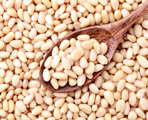 Pine nut in a wooden spoon, background. The view from the top