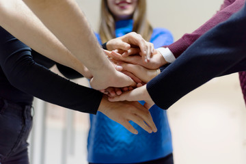 Young business people Teamwork Stacking Hand Concept. Close up of young  business people putting their hands together. Friendly business people  with stack of hands showing unity and teamwork.