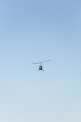 Flying helicopter in the blue sky