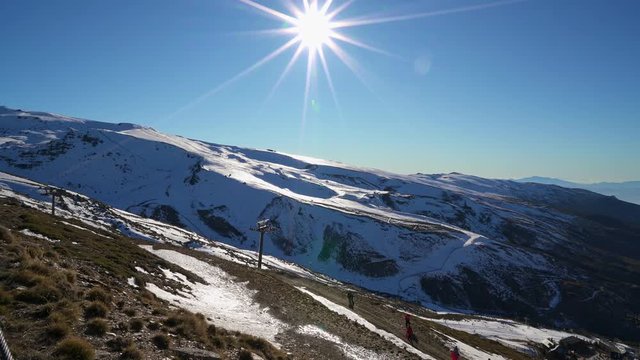 Panorama of Ski resort of Sierra Nevada in winter, full of snow, with unrecognizable man doing cross-country skiing under bright sun